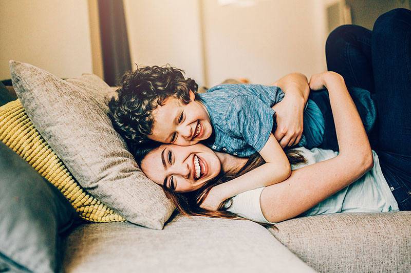 Mother and son smiling on the couch